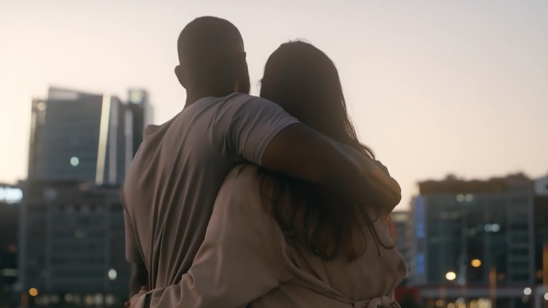 A Couple Hugging While Looking at The City Skyline at Sunset