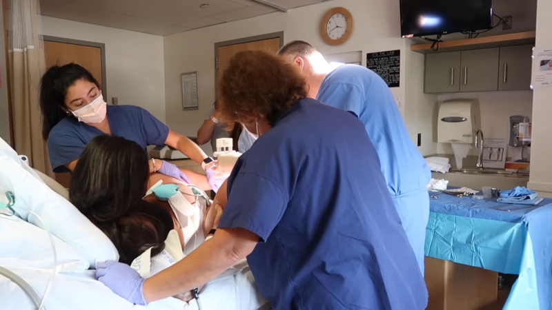 Medical Professionals Assisting a Woman During Childbirth