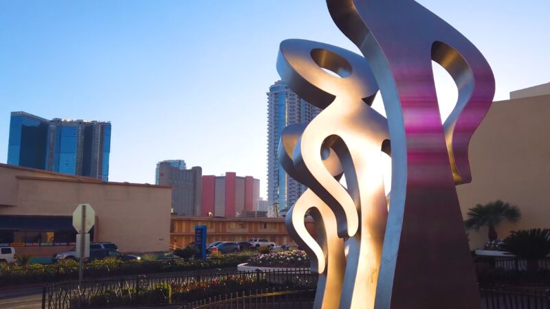 An Artistic Metallic Sculpture with Ribbon-Like Elements Stands in Front of High-Rise Buildings in Las Vegas