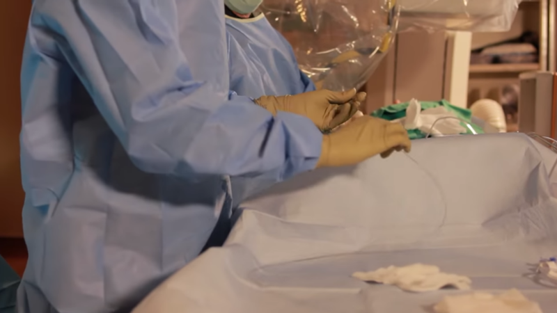 A Medical Professional Prepares Equipment for A Cardiac Catheterization Procedure