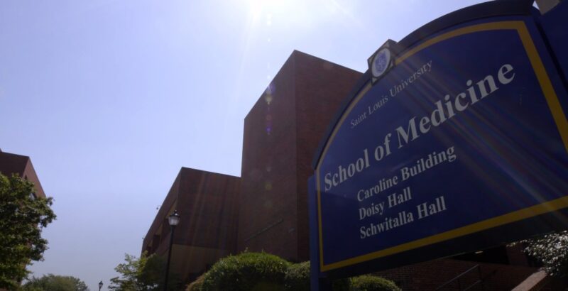 A Sign for Saint Louis University’s School of Medicine in Front of Brick Buildings