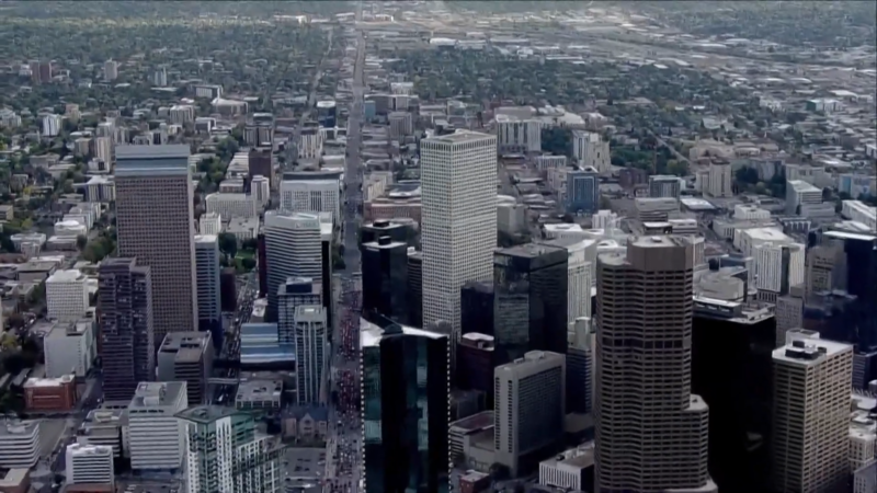 Aerial View of A Densely Packed Urban Area with Numerous High-Rise Buildings and Skyscrapers, Surrounded by Sprawling Residential Neighborhoods, Likely Depicting the Skyline of A Major City in Colorado