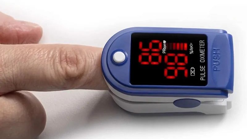 A Finger Inserted Into a Pulse Oximeter Showing Oxygen Saturation Levels on Its Display