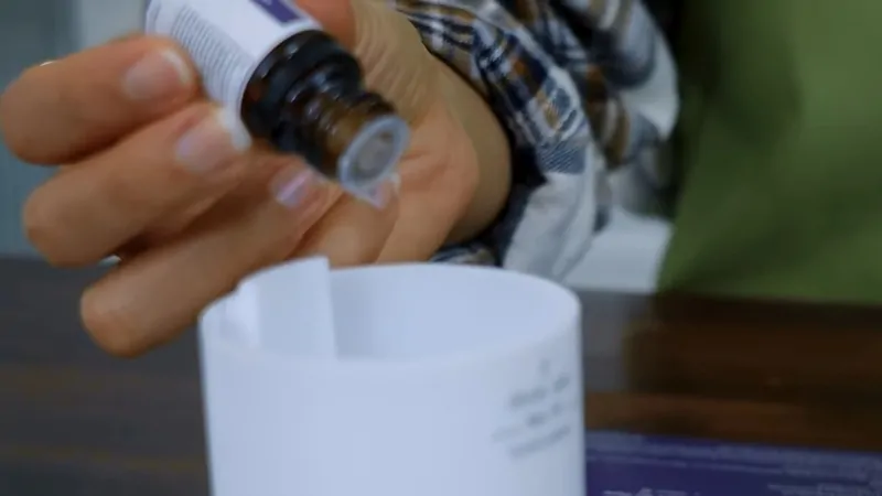 A Person Adding Essential Oil to A Diffuser