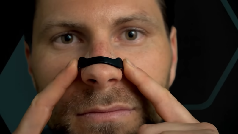 A Man Applying a Nasal Strip to Improve Airflow