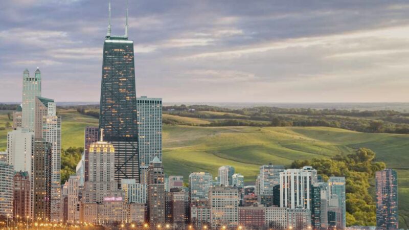 The Image Depicts a Juxtaposition of Urban and Rural Environments in Illinois, Showcasing a Dense City Skyline Merging Seamlessly with Expansive, Rolling Green Countryside