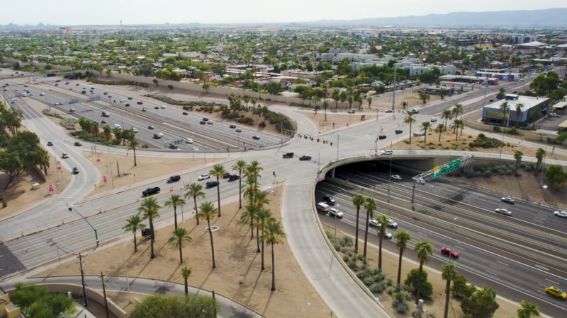 An Aerial View of A Major Highway Intersection in Arizona Surrounded by Palm Trees, Buildings, and Residential Areas, Showcasing Urban Development and Growth