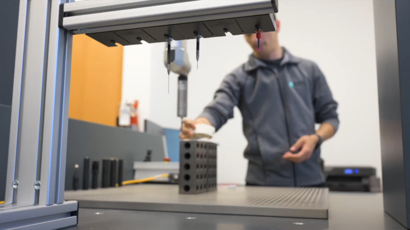 The Image Shows a Person Operating Advanced Industrial Equipment in A Modern Facility, Focusing on Precision Measurement Tools, Representing the Commercial and Industrial Growth in Minneapolis.