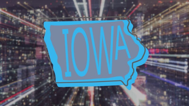 Neon Outline of Iowa's Map Superimposed on A Blurred Cityscape at Night, Symbolizing the Dynamic Changes and Future Projections for Iowa's Population in 2024