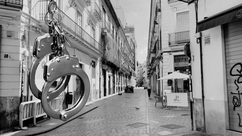 Giant Handcuffs as A Street Art Installation Hanging Over a Narrow Alley in Valencia