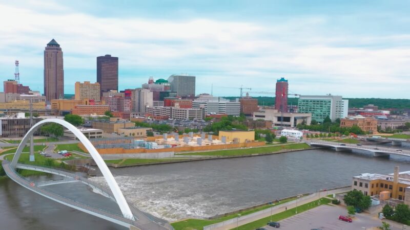 A Panoramic View of A City in Iowa Showing a Mix of Modern and Traditional Buildings Along a River, Representing Iowa's Population and Urban Landscape