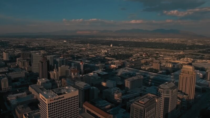 Aerial View of Utah's Urban Skyline with Densely Packed Buildings and A Sprawling Cityscape Extending Toward Distant Mountains, Illustrating Population Concentration