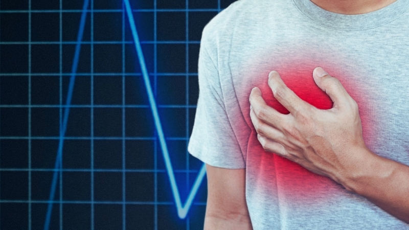 A Man Holding His Chest in Pain, Possibly Experiencing Symptoms of Heart Disease