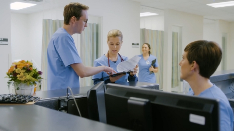 Nurses in A Hospital Setting Discussing Patient Files, Highlighting Teamwork in BSN Programs