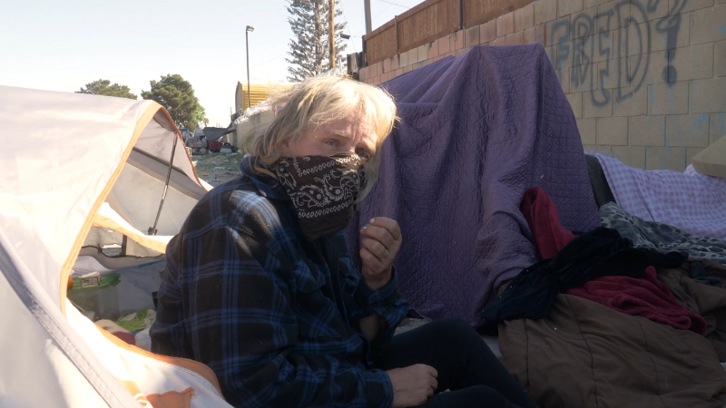 A Homeless Woman Sits Next to Makeshift Shelters in Antelope Valley