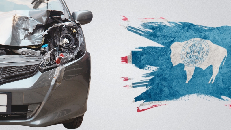 A Damaged Car Next to An Artistic Rendering of The Wyoming State Flag