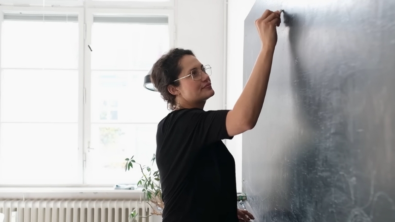 A Teacher Writing on A Blackboard in A Classroom