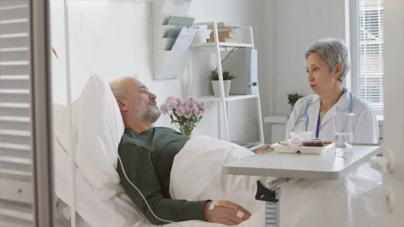 Doctor sitting next to a hospitalized patient