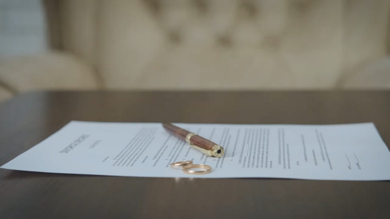 A Divorce Document and Wedding Rings on A Table