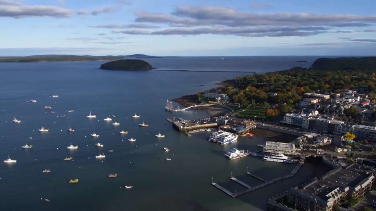 Boats sit in a Maine harbor beside a coastal town