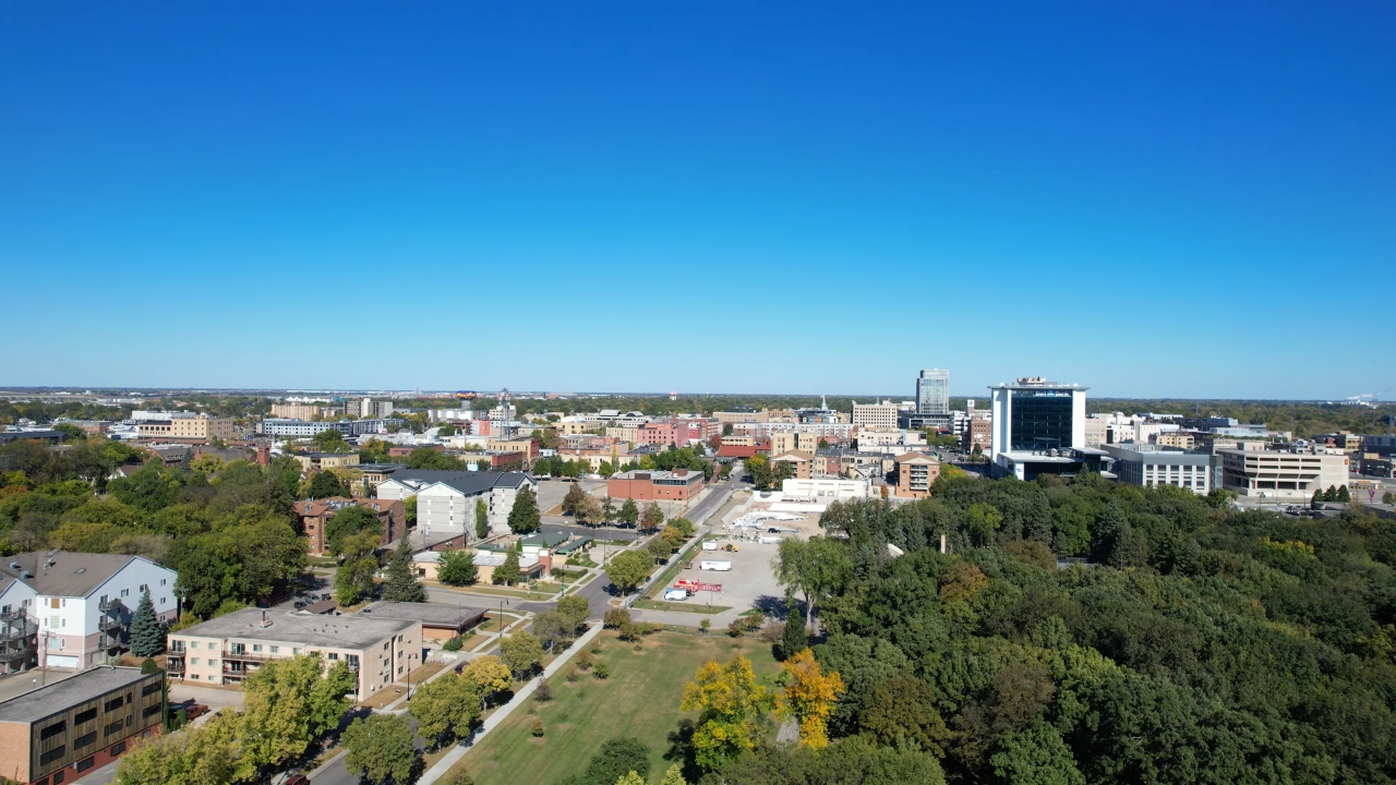 A North Dakota city skyline stretches across a clear blue sky