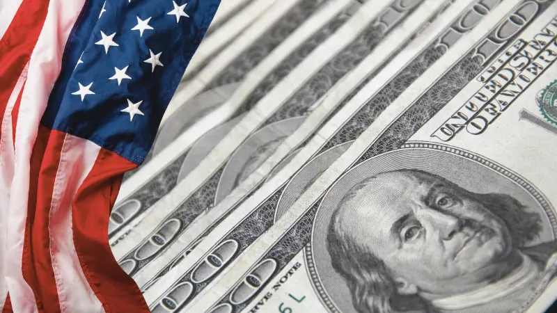 An Image Showing U.S. Currency Alongside the American Flag