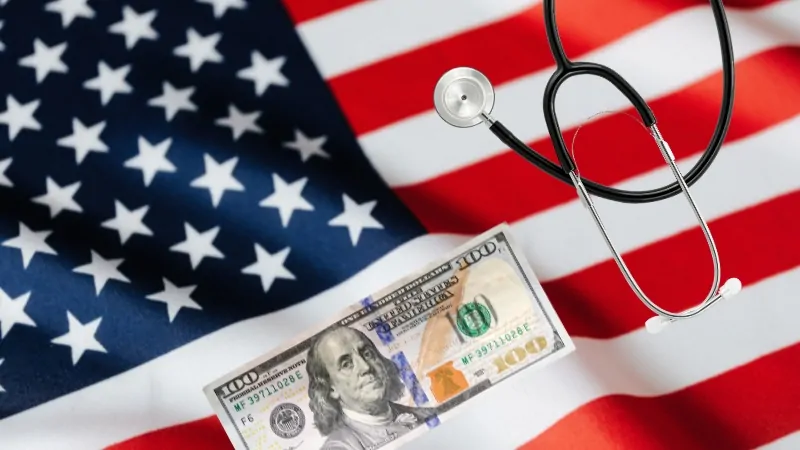 Stethoscope and $100 Bill on The U.S. Flag, Symbolizing Private vs. Public Health Insurance