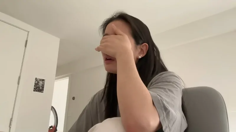 A Teenage Girl Covers Her Face with Her Hand While Sitting in A Room, Symbolizing the Struggle of Teen Depression in The Us