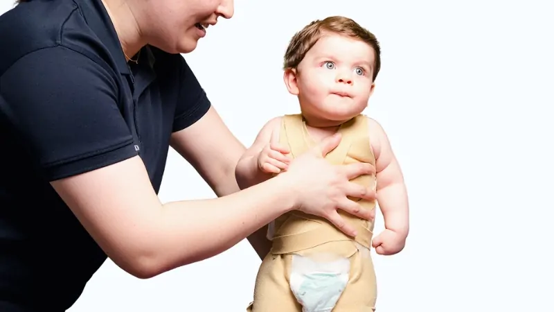 A Child Receives Support from Thera Togs, a System Designed to Aid in Postural Correction and Improve Alignment