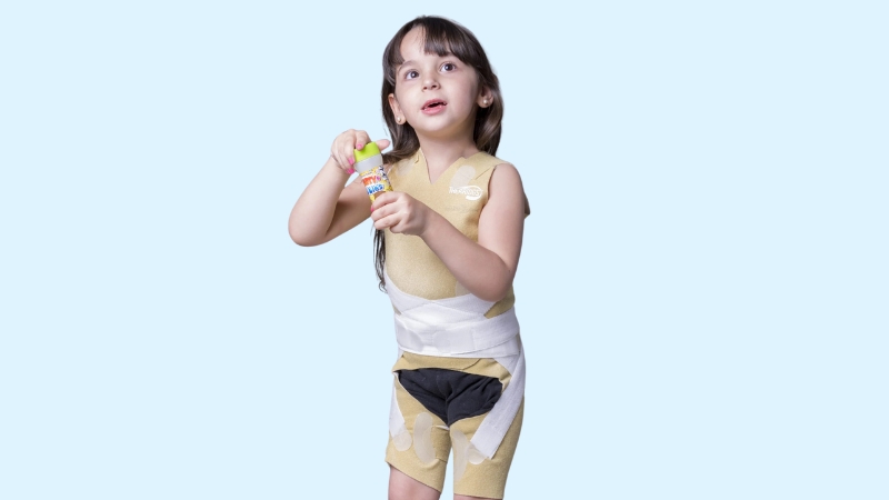 A Child Wearing Thera Togs, Designed to Support Postural Correction While Engaging in A Fun Activity