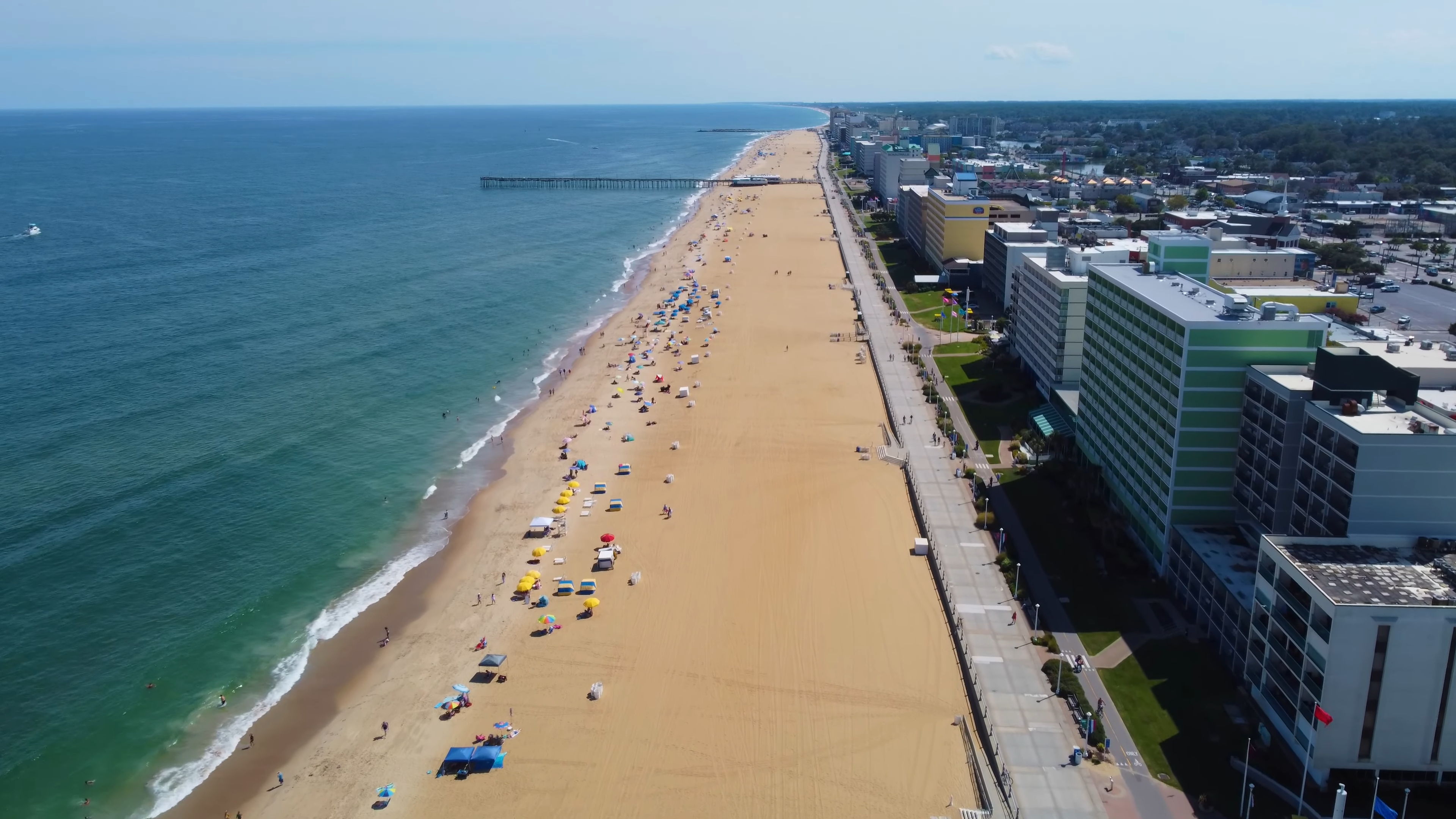 Aerial View of The Virginia Beach Coastline with Beachgoers, Hotels, and The Ocean, Representing the Virginia Beach Population