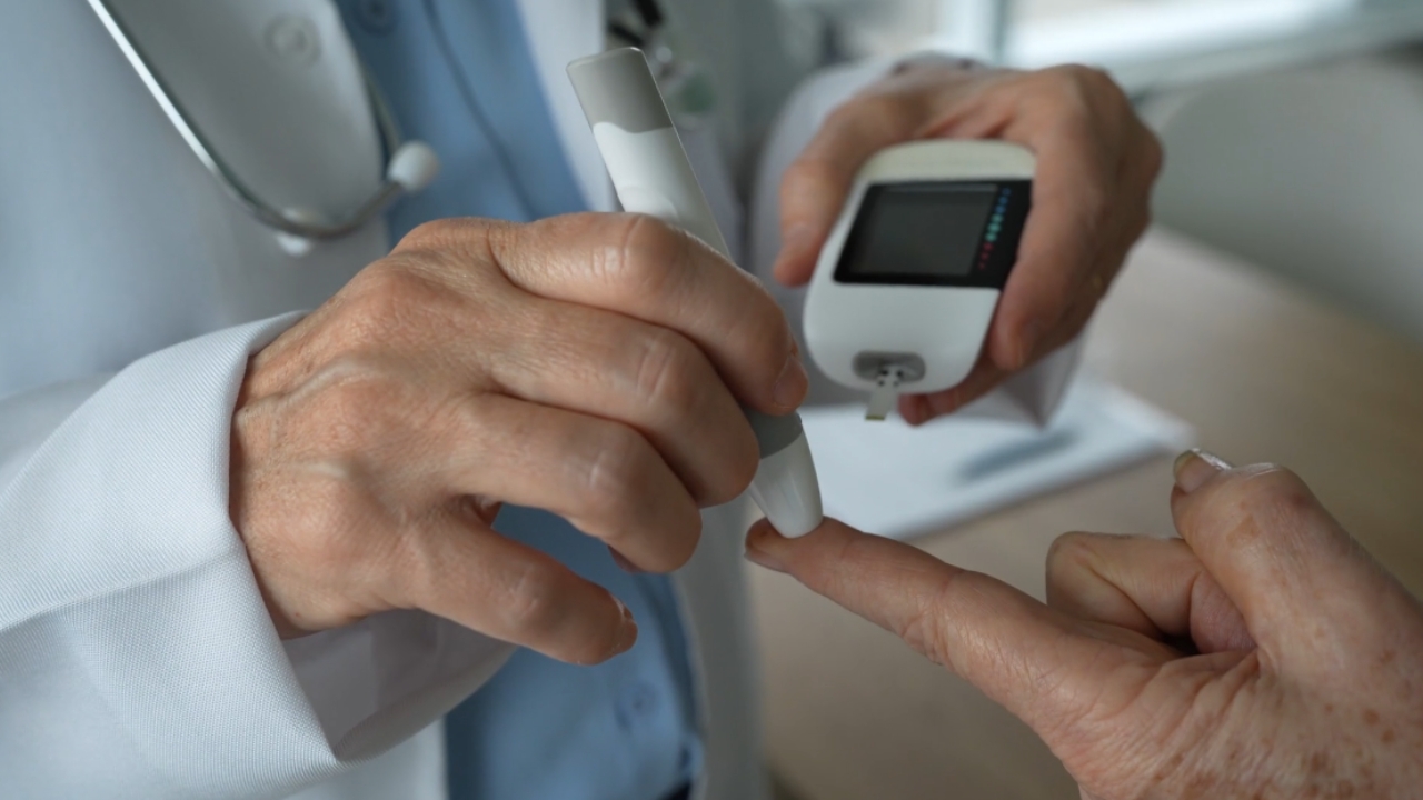 A doctor checks a patient’s blood sugar with a glucose meter