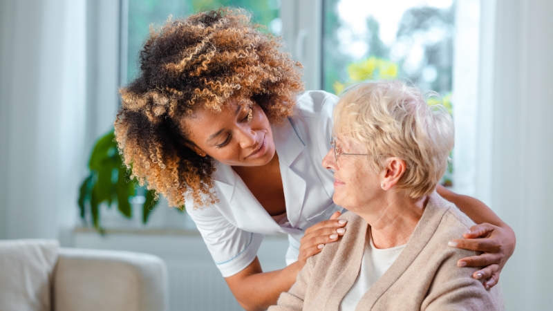 A caregiver talks with an elderly woman, showing the personal care in the U.S. home care industry