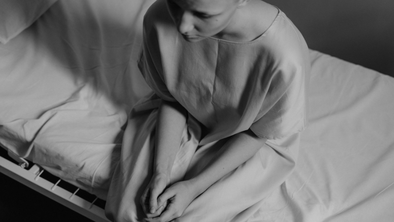 A person sits alone on a hospital bed, showing the emotional toll of bipolar disorder hospitalizations in the U.S.