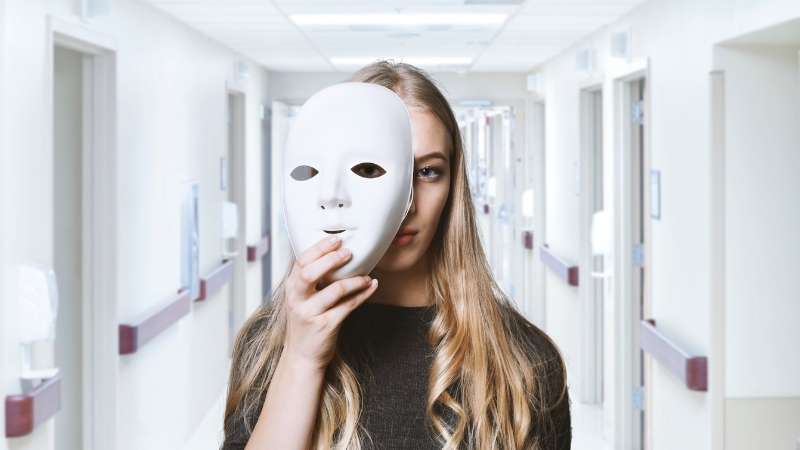 A woman in a hospital holds a mask, showing the hidden effects of bipolar disorder during COVID-19
