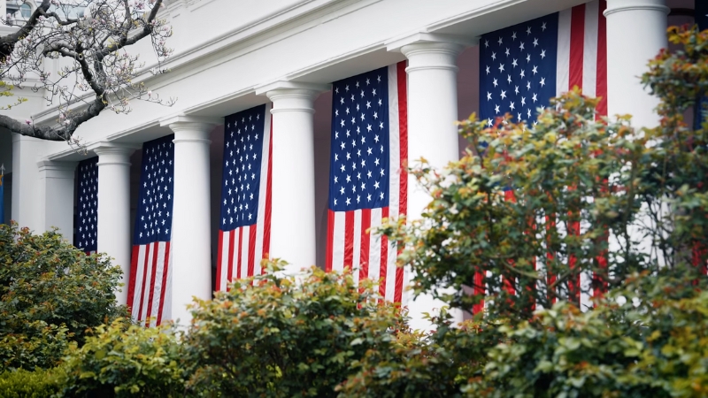 American flags displayed on columns of a building, symbolizing the U.S. federal workforce