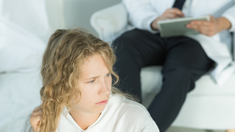 A young woman sits in a clinic, showing the need for better bipolar disorder care
