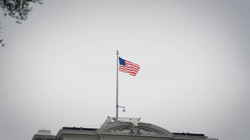 The American flag flying above a government building