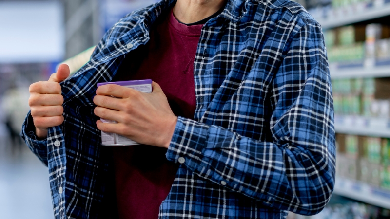 A person caught shoplifting, representing a common impulse control disorder like kleptomania