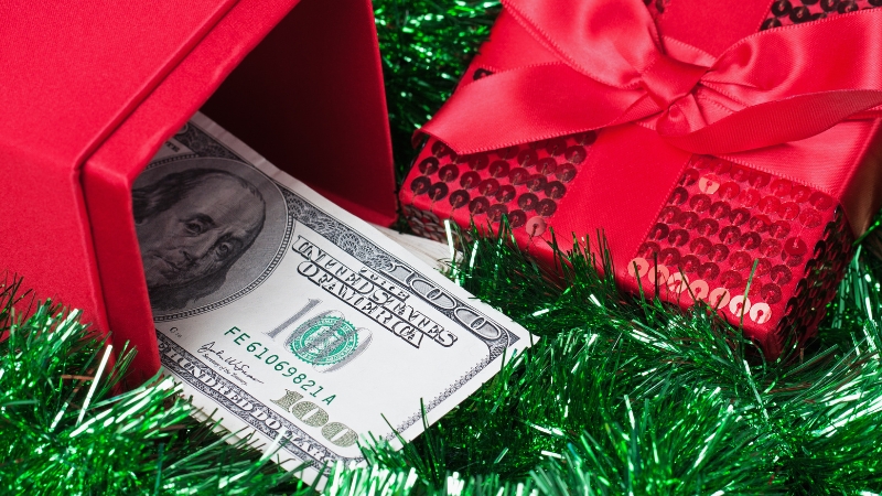 A red gift box with a $100 bill showing U.S. gift spending by income level