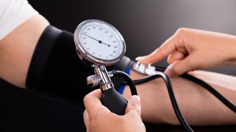 A person gets their blood pressure checked with a manual cuff to see if it's in the healthy range for their age