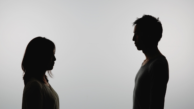Silhouettes of a man and woman face each other, representing gender differences in average heights and weights across regions