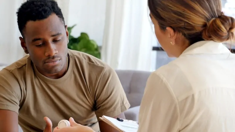 A man talks with a healthcare provider about PTSD treatment, reflecting challenges many face in accessing care