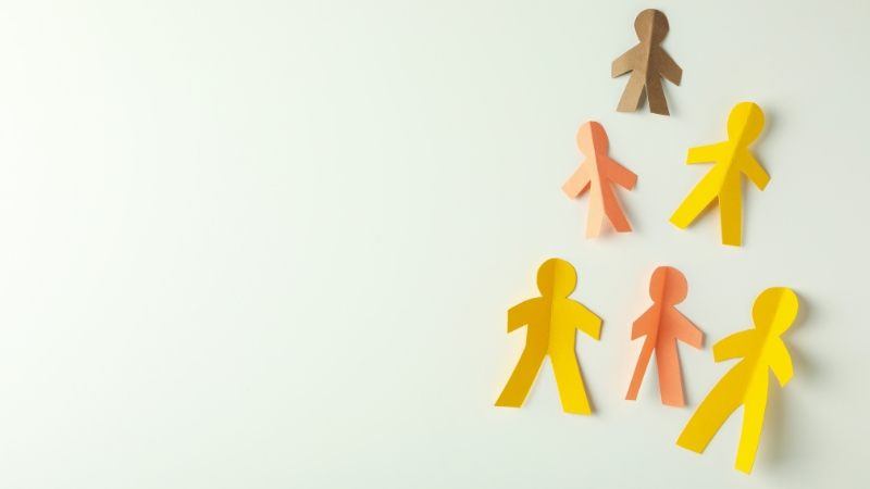 Colorful paper cutouts of people arranged in a pattern show the trend toward smaller families and population decline