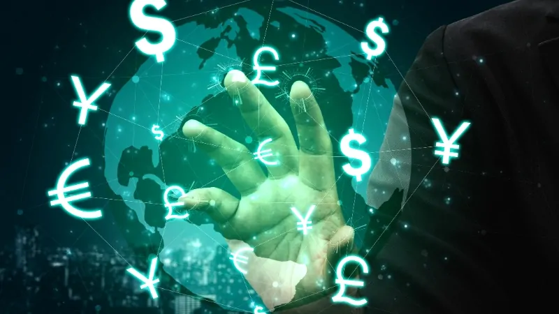 A person’s hand reaching toward glowing currency symbols around the globe, showing the concept of the lowest currency in 2025