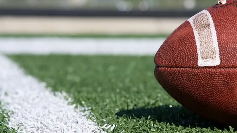 NFL teams average game attendance in 2024 shown with a closeup of a football on the field