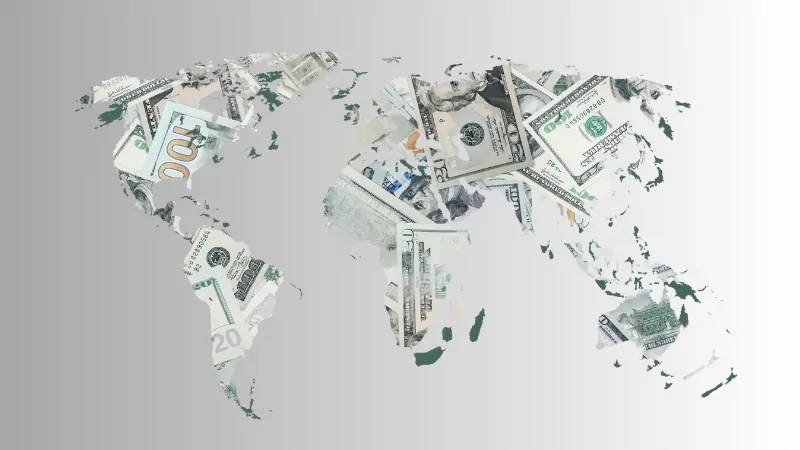 World map illustration filled with banknotes, symbolizing the 2025 discussion on how much money is there in the world