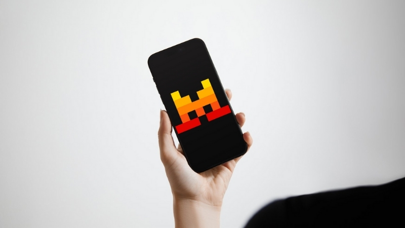 A person holding a smartphone with the Mistral AI logo displayed on the screen