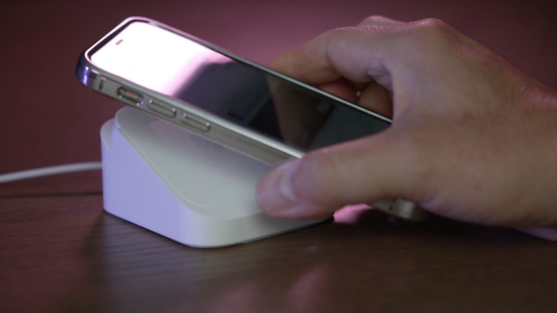 A person uses an iPhone on a wireless payment terminal, showing the growth of mobile payments in the U.S.
