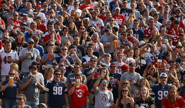 A sea of cheering fans in team jerseys during NFL game